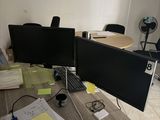 un bureau sur lequel sont posés deux écrans et un ordinateur portable