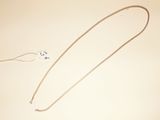 a necklace that is laying on a table next to a pair of scissors