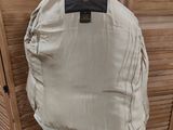 the back of a jacket on a mannequin stand in front of a wooden wall