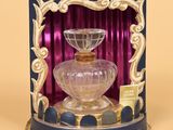 a glass perfume bottle with a gold trim around it