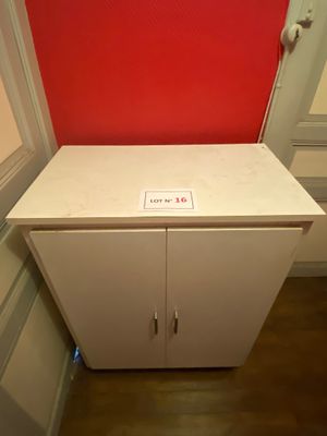 a white cabinet with a red wall behind it