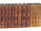 une image représentant une rangée de vieux livres posés sur une surface blanche