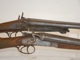 two old guns are on display in a glass case