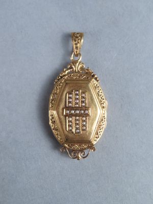 une broche en or ornée d'une croix sur un fond bleu
