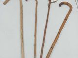 three wooden walking canes and a book on a white surface
