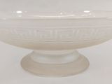 white glass bowl sitting on top of a pedestal on a white surface