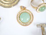three rings and a ring with a green stone on it