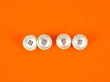 une paire de boucles d'oreilles en argent et perles sur fond orange