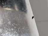 a black bug that is sitting on the edge of a piece of metal