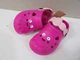 pair of pink children ' s crocs with a pink bow on the side