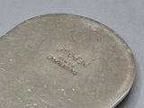 two silver spoons sitting next to each other on a table