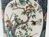 a vase that has a bird and flowers on it