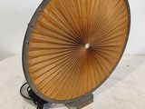 un grand ventilateur en bois posé sur une surface blanche