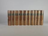 six livres anciens alignés sur une surface blanche
