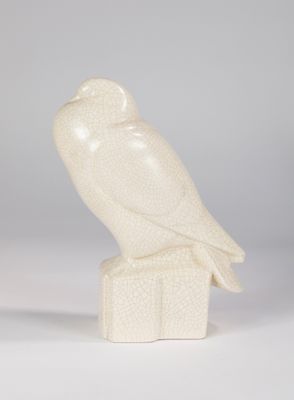 white owl figurine sitting on top of a wooden block