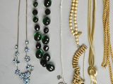 many different types of necklaces and bracelets on the table