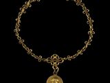 Gros plan sur un bracelet en or orné d'une pièce de monnaie