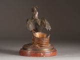 a statue of a bird sitting on top of a bowl