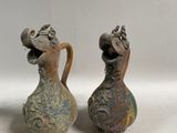deux vases posés l'un à côté de l'autre sur une surface blanche