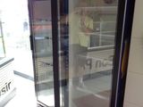 un homme debout devant un réfrigérateur dans un magasin