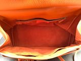 an orange purse with a zipper on the inside of it