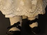 a close up picture of a doll wearing a dress and shoes