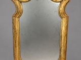 un miroir à cadre doré orné d'un motif décoratif sur le pourtour