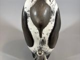 sculpture of a bird with a black and white body and a brown beak