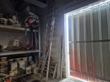 une pièce avec une échelle, des étagères et une fenêtre