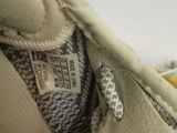 someone is holding a pair of shoes with a label on them