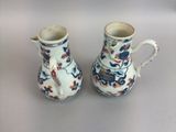 pair of blue and white vases with flowers on them on a table