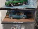 three toy cars in a display case on a table