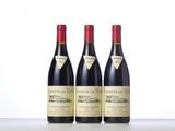 three bottles of wine are lined up on a table