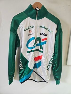 une veste verte et blanche ornée d'un logo représentant un chat