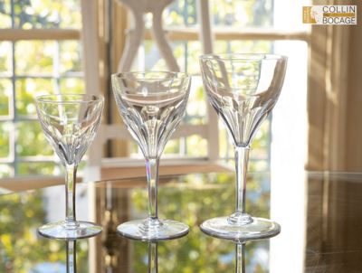 trois verres à vin posés sur une table devant une fenêtre