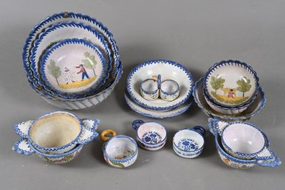 Plusieurs pièces de poterie bleue et blanche sont disposées sur une surface grise