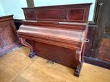 a piano that is sitting in a room next to a wall