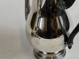 a silver coffee pot sitting on a white table