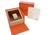 an orange box with a watch inside of it on a white surface