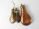 two antique brass pears and a brass pepper shaker on a white background