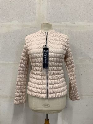 the jacket is on a mannequin stand in front of a brick wall