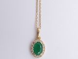 a green jade and diamond pendant on a gold chain
