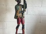 a statue of a man holding a candelab on a pedestal