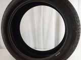 a close up of a tire on a white surface with a curtain in the background
