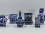 several blue and white vases are lined up on a white surface