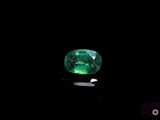 a close up of a green emerald stone on a black surface