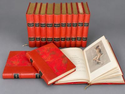 an open book sitting on top of a table next to a stack of books