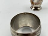 a silver bowl and a silver cup sitting on a table