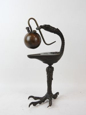 sculpture of a bird with a lamp on it ' s head sitting on a table