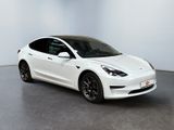 a white tesla model 3 parked in a white room